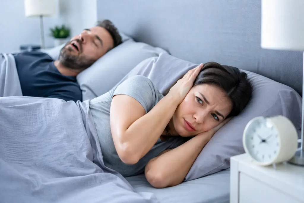 Donna insonne disturbata dal russare del partner durante la notte.