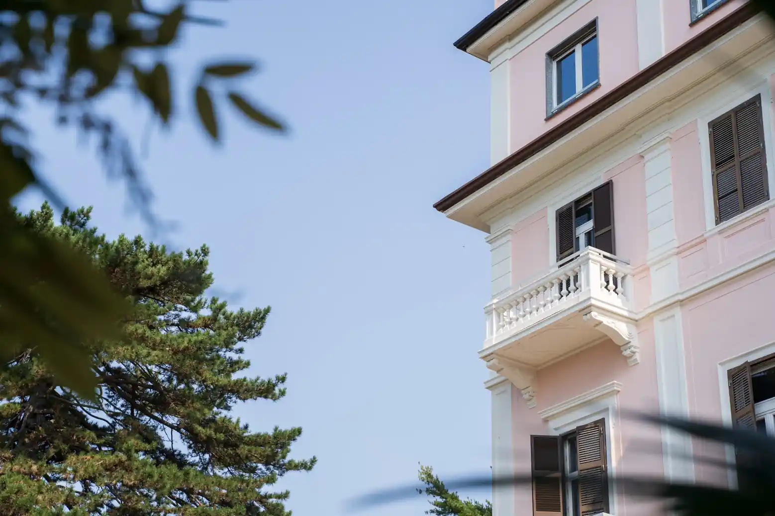 Particolare della facciata rosa e del balcone della villa storica di Clinica La Quiete.