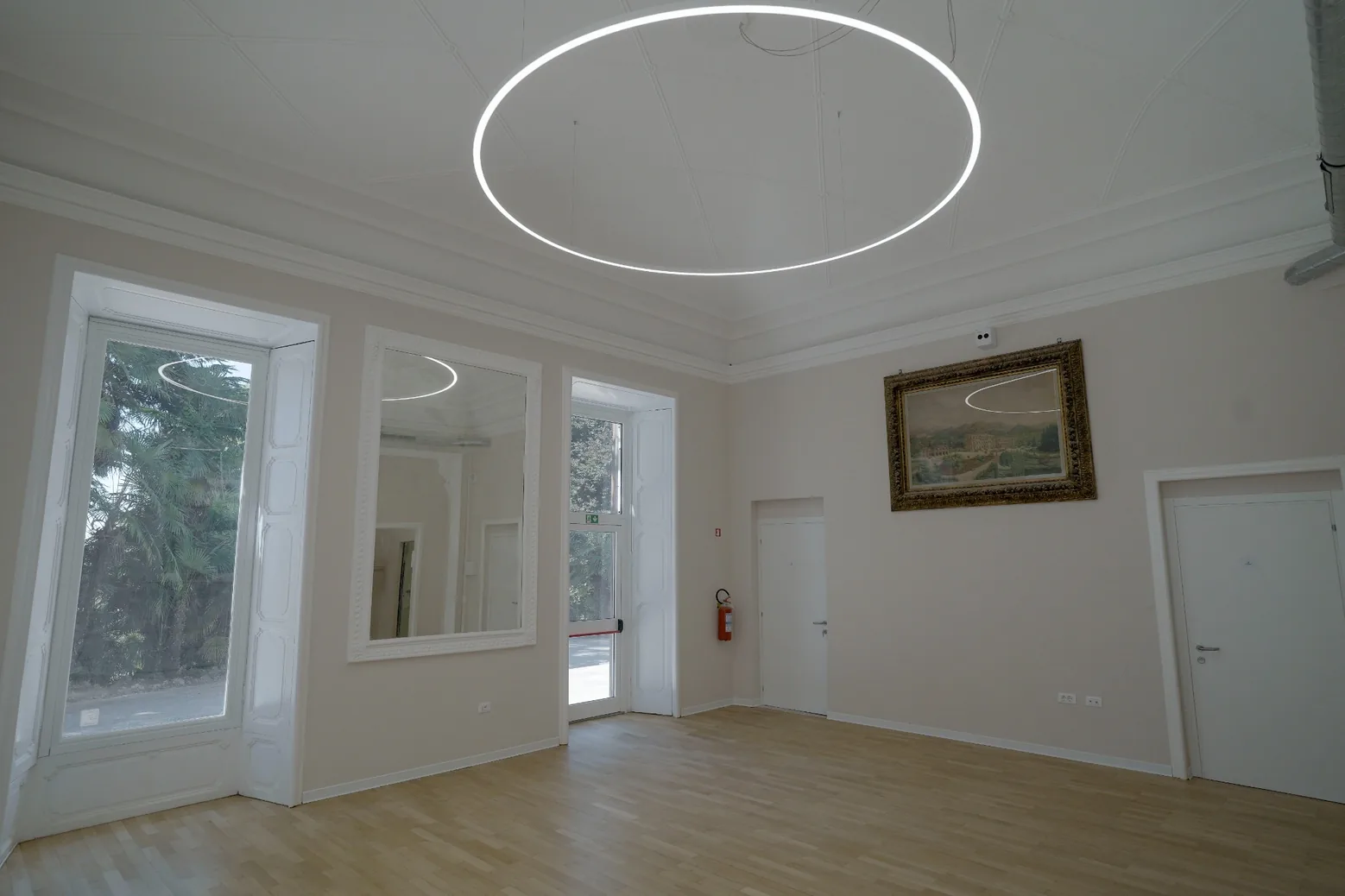 Ampia sala luminosa con pavimento in legno nella villa storica di Clinica La Quiete.